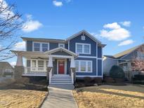 Charming two-story home with blue siding, a red front door, a covered porch, and a well-maintained yard at 375 N Serenity Hill Cir, Chapel Hill, NC 27516