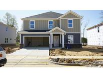 Two-story home with a gray exterior, attached garage, and unfinished landscaping in a new development at 3837 Rosebush Dr, Zebulon, NC 27597