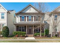Charming two-story home with a brick facade, inviting front porch, and well-manicured landscaping at 4108 Overcup Oak Ln, Cary, NC 27519