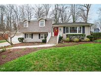 Charming two-story home featuring a landscaped yard, brick accents and a bright red front door at 4209 Converse Dr, Raleigh, NC 27609