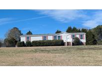 Charming single-story home with blue siding, red trim, and mature landscaping under a clear blue sky at 4600 Strawbush Rd, Spring Hope, NC 27882