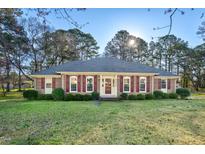 Charming brick home with red shutters, manicured lawn, and mature trees for curb appeal at 5013 Kristie Ln, Nashville, NC 27856
