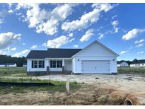 Charming single-story home with white siding, a two-car garage, and black shutters in a developing neighborhood at 59 Pagani Dr, Kenly, NC 27542