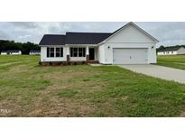 Charming one-story home featuring a manicured lawn and an attached two-car garage at 59 Pagani Dr, Kenly, NC 27542