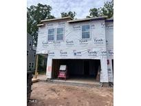 Exterior view of a house under construction, covered with Tyvek wrap and showing window openings at 6968 Doddridge Ln # 11, Cary, NC 27519