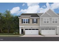 Charming townhome with attached garage and a blend of stone and siding accents under a sunny sky at 6968 Doddridge Ln # 11, Cary, NC 27519