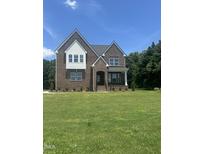 Beautiful two-story brick home featuring large front lawn and classic architectural details in a desirable neighborhood at 9000 Penny Rd, Raleigh, NC 27606