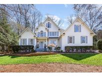 Stately white brick home with manicured lawn and detailed blue shutters at 9700 Pentland Ct, Raleigh, NC 27614