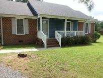 Charming brick and blue home with a well-maintained lawn and inviting front porch at 103 Crestwater Ct, Louisburg, NC 27549