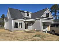 New two-story home featuring gray siding, black shutters, and an attached garage at 1039 N Lincoln St, Benson, NC 27504