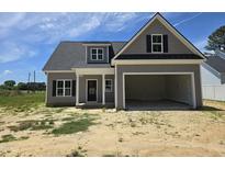 New gray home featuring a large two car garage, black shutters and a covered front porch at 1039 N Lincoln St, Benson, NC 27504