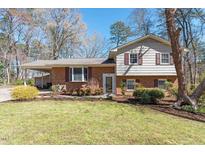 Charming home with brick and siding, landscaped front yard, and a covered carport at 112 Celeste Cir, Chapel Hill, NC 27517