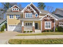 Inviting two-story home featuring a charming porch, two-car garage, and craftsman details at 121 Homegate Cir, Apex, NC 27502