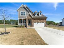Beautiful two-story home featuring stone and gray wood, attached two-car garage, and a well-manicured front yard at 125 Scotland Dr, Youngsville, NC 27596