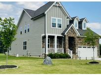 Charming two-story home with stone accents, white trim, manicured lawn, and attached garage at 125 Scotland Dr, Youngsville, NC 27596