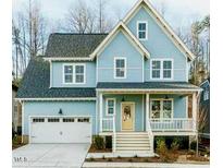 Charming light blue two-story home with white trim, covered porch, and a two-car garage at 201 Bluffwood Avenue, Chapel Hill, NC 27516