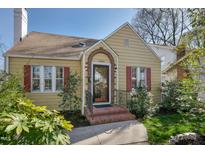 Charming bungalow with red shutters, brick-framed front door, and professionally landscaped front yard at 2401 Englewood Ave, Durham, NC 27705