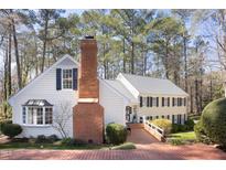 Charming two-story home with brick walkway, detailed brick chimney, manicured shrubs, and mature trees at 3508 Cambridge Rd, Durham, NC 27707