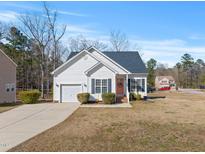 Charming single-Gathering home with white siding, black shutters and a cozy front yard on a sunny day at 3517 Glade Run Dr, Sanford, NC 27330