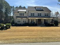 Charming two-story home with gray siding, dormer, and covered front porch, surrounded by a well-manicured lawn at 5600 Abbey Grace Ln, Wake Forest, NC 27587