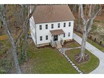 Charming two-story home with a landscaped yard, stone pathway, and inviting covered entryway at 612 Lakeview Dr, Raleigh, NC 27603