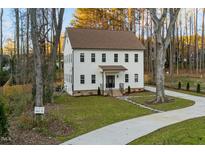 Charming three-story home boasting a manicured lawn, stone pathway, and elegant white siding at 612 Lakeview Dr, Raleigh, NC 27603