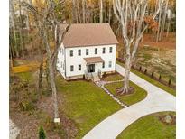 Charming two-story home featuring a lush green lawn, stone walkway, and a freshly paved driveway at 612 Lakeview Dr, Raleigh, NC 27603