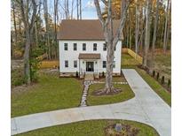 Charming two-story home featuring a well-manicured lawn, stone walkway, and a long, paved driveway at 612 Lakeview Dr, Raleigh, NC 27603