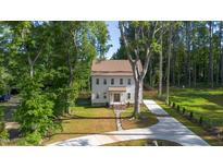 Charming two-story home with a well-manicured lawn and a long driveway surrounded by lush greenery at 612 Lakeview Dr, Raleigh, NC 27603