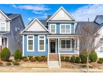 Charming blue two-story home with landscaped front yard and inviting front porch at 6416 Truxton Ln, Raleigh, NC 27616