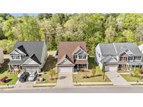 Charming two-story home featuring a well-manicured lawn and a two-car garage, surrounded by lush trees and blue skies at 69 Florence Dr, Clayton, NC 27527