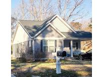 Charming home featuring gray siding, a cozy porch, and well-maintained landscaping at 8 Elaine Cir, Durham, NC 27703