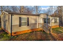 Charming single-Gathering home with neutral siding, black shutters, and inviting entry stairs at 8237 Oak Grove Church Road Rd, Liberty, NC 27298