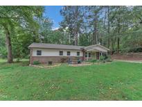 Charming single-story home with brick accents, a cozy front yard, and a welcoming green front door at 913 Ranch Farm Rd, Raleigh, NC 27603