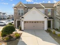 Charming townhome showcasing brick and siding with a two-car garage and well-maintained landscaping at 1003 Mirbeck Ln, Durham, NC 27713
