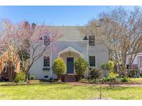 Charming two-story home with a brick walkway and flowering trees in a well-maintained front yard at 1010 Rosehill Ave, Durham, NC 27705