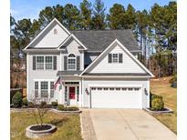 Charming two-story home with a red front door, white siding, and a well-manicured lawn at 104 Vinewood Pl, Holly Springs, NC 27540