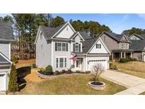 Charming two-story home with manicured lawn and two car garage at 104 Vinewood Pl, Holly Springs, NC 27540