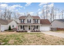 Charming two-story home with a welcoming front porch, beautiful landscaping, and an attached two-car garage at 1044 S Philwood Ct, Fuquay Varina, NC 27526