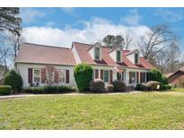 Charming one-story home boasts a well-manicured lawn, red shutters, dormers, and a timeless American flag at 1308 Drivers Cir, Rocky Mount, NC 27804