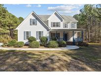 Charming two-story home with blue accent porch and manicured shrubbery in the front yard at 1324 Emerson Cook Rd, Pittsboro, NC 27312