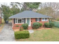 Charming one-story red brick home with a well-manicured lawn and a welcoming front entrance at 1406 Watts St, Durham, NC 27701