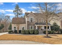 Charming two-story home features a stone and siding exterior, mature landscaping, and inviting front porch at 1416 Endgame Ct, Wake Forest, NC 27587