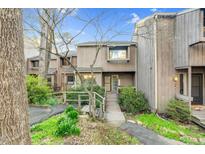Inviting townhouse exterior features a wooden bridge, lush landscaping, and a charming front entrance at 198 Ridge Trl, Chapel Hill, NC 27516