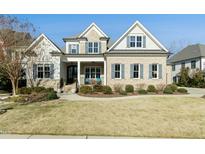 Charming two-story home featuring a manicured lawn, and inviting covered porch with blue accents at 2046 Fellini Dr, Apex, NC 27502