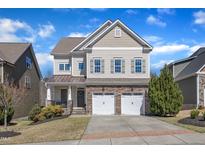 Charming two-story home featuring a two-car garage and landscaped front yard on a sunny day at 205 Virginia Water Dr, Rolesville, NC 27571