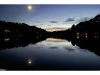 Scenic lake view at dusk with reflections and trees silhouetted against the sky and full moon at 2140 N Lakeshore Dr, Chapel Hill, NC 27514