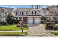 Charming two-story home with a two-car garage, landscaped yard, and covered porch at 233 Candia Ln, Cary, NC 27519