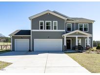 Charming two-story home features a two-car garage and a welcoming front porch with stylish columns at 2575 Sheriff Watson Rd, Sanford, NC 27332