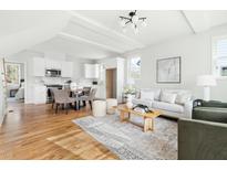 Open-concept living room flows into the dining area and kitchen with an abundance of natural light and hardwood floors at 2816 Cascadilla St, Durham, NC 27704